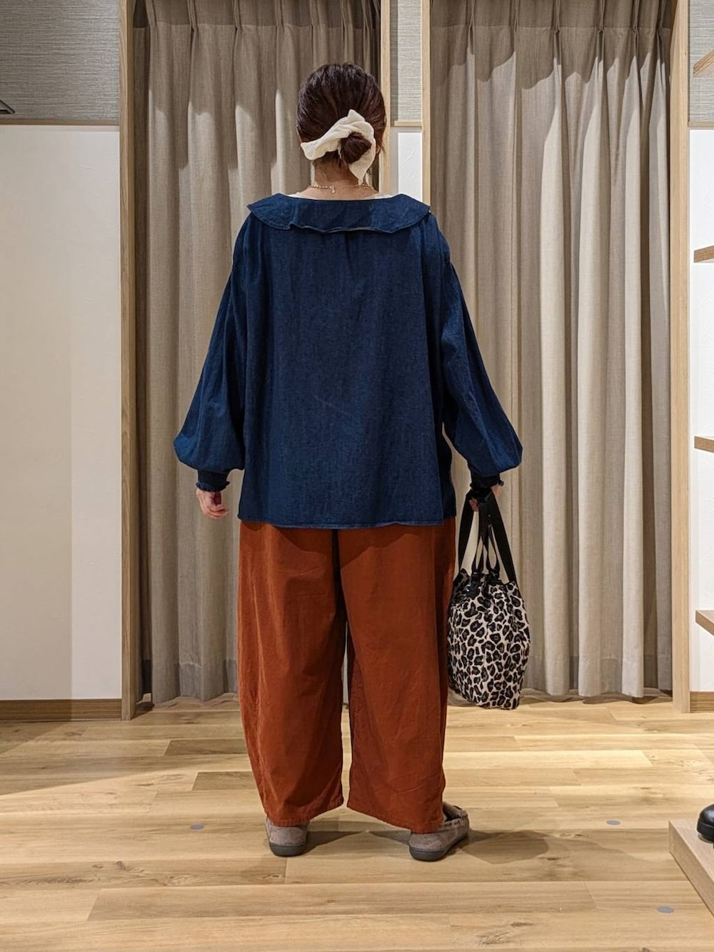 ブルー系のシャツ/ブラウス、オレンジ系のその他パンツ、ホワイト系のTシャツ/カットソーを着用したレディースの秋コーディネートの3枚目の写真