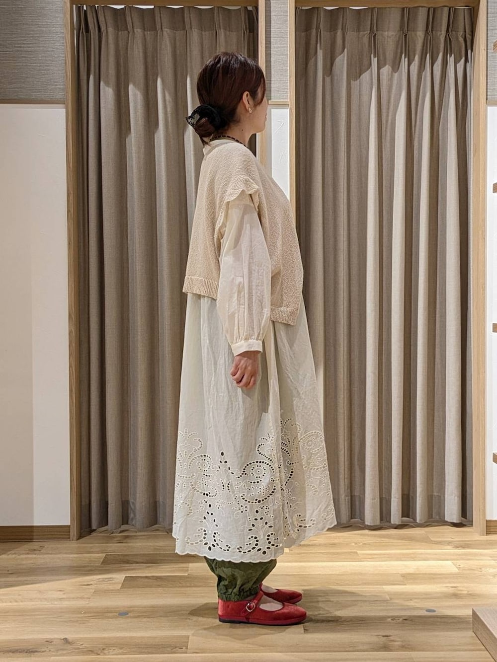 グリーン系のその他パンツ、レッド系のその他シューズ、ベージュ系のニット/セーターを着用したレディースの秋コーディネートの2枚目の写真