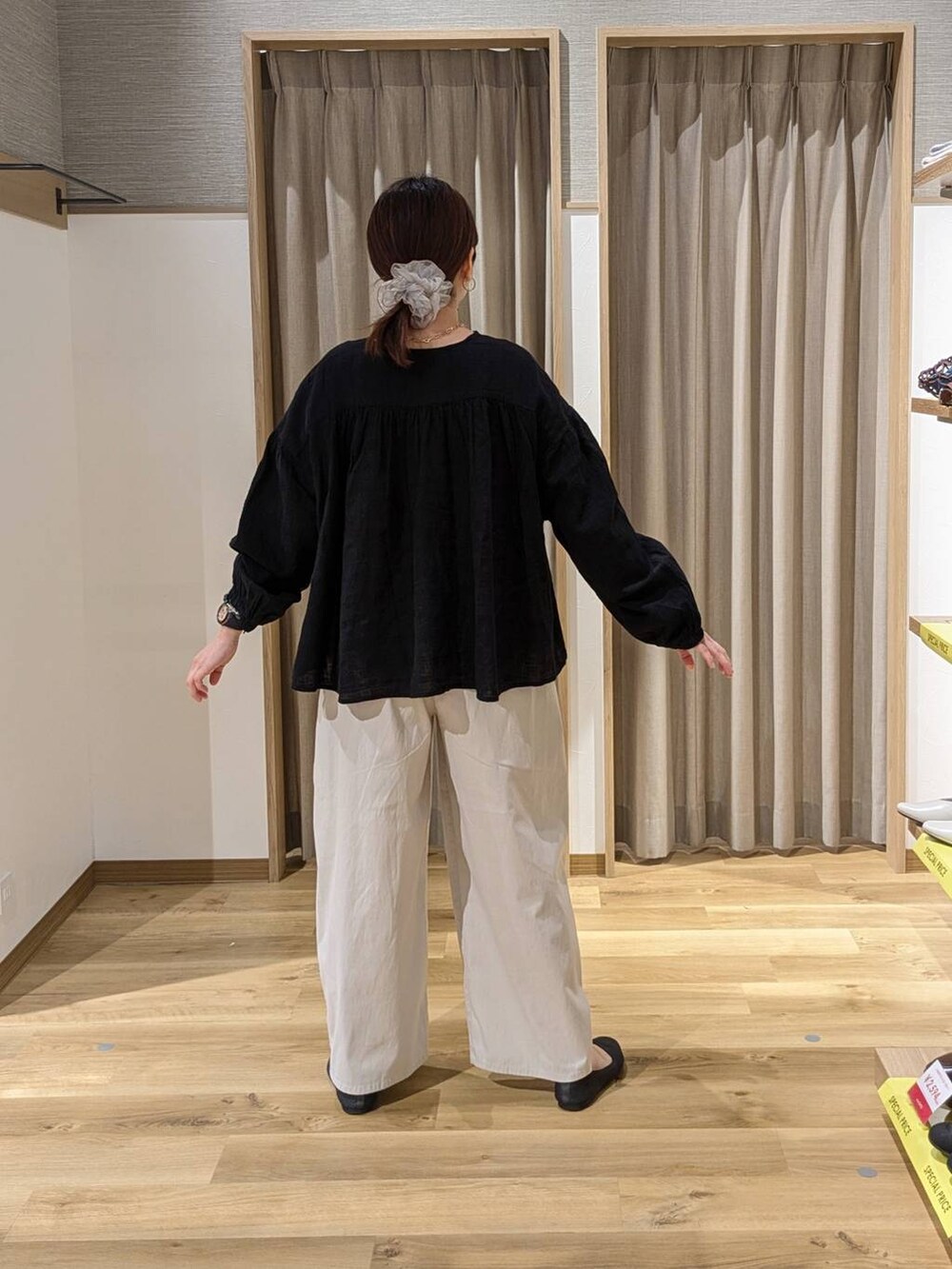 ブラック系のシャツ/ブラウス、ブラック系のトートバッグ、グレー系のパンプスを着用したレディースの春コーディネートの2枚目の写真