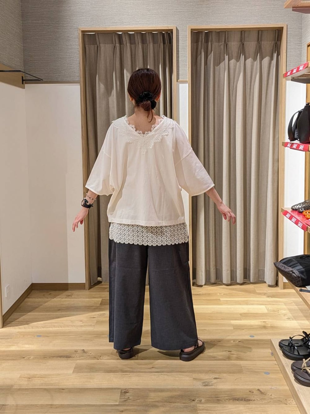 ブラウン系のトートバッグ、ブラウン系のサンダル、グレー系のその他パンツを着用したレディースの夏コーディネートの2枚目の写真