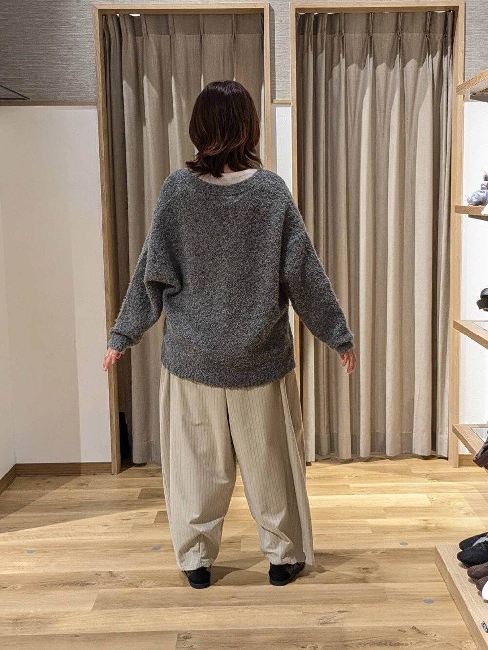 ホワイト系のTシャツ/カットソー、グレー系のカーディガン/ボレロ、ブラウン系のショルダーバッグを着用したレディースの冬コーディネートの2枚目の写真