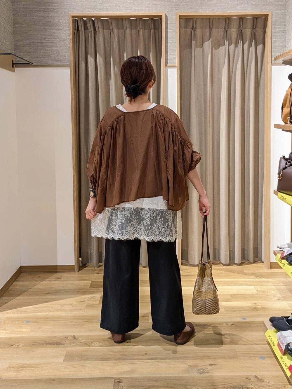 ピンク系のトートバッグ、ブラウン系のパンプス、ブラック系のその他パンツを着用したレディースの春コーディネートの2枚目の写真