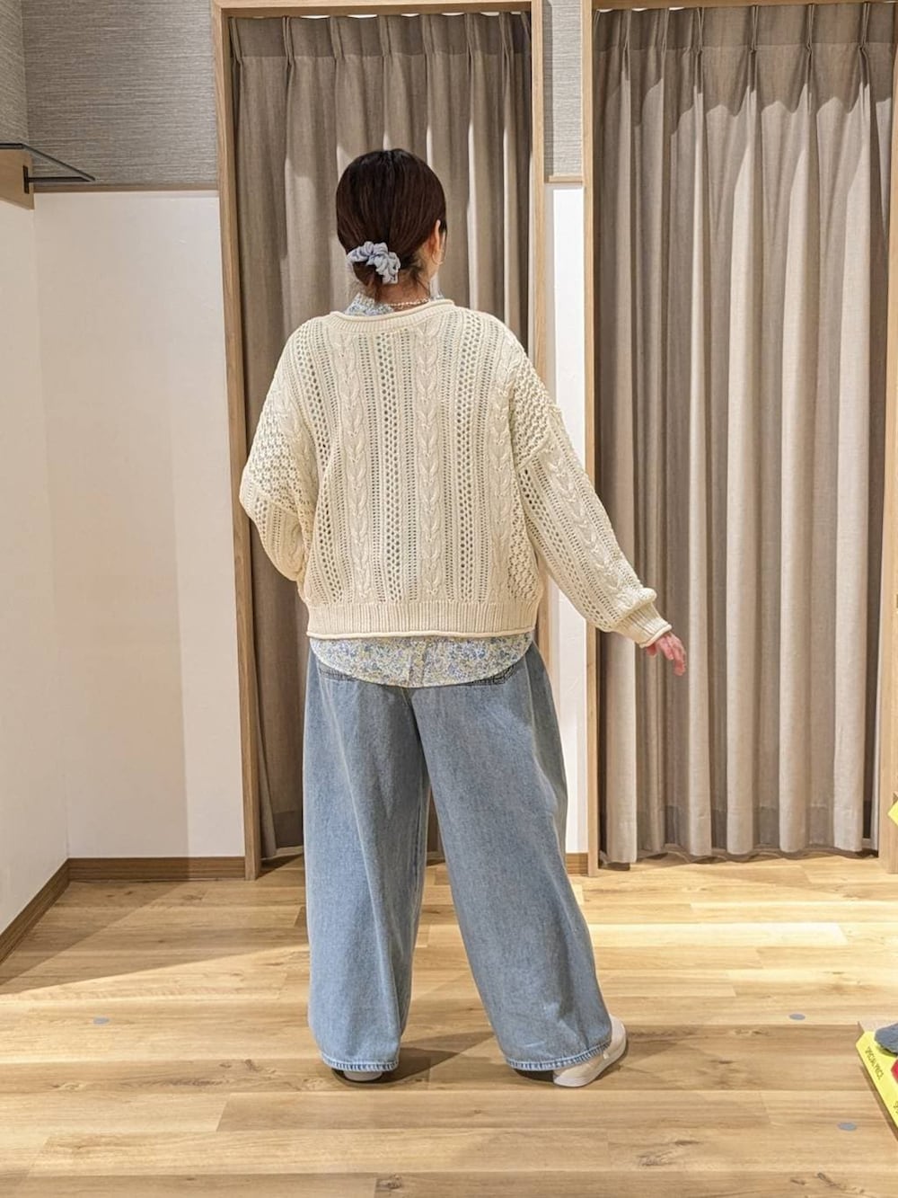 ブルー系のデニムパンツ、ホワイト系のスニーカー、グリーン系のトートバッグを着用したレディースの冬コーディネートの3枚目の写真