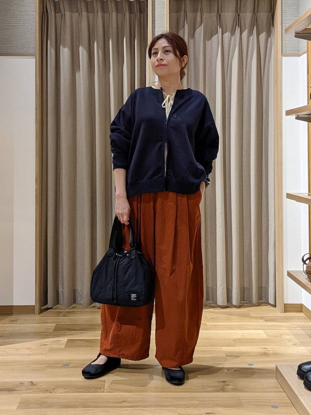 オレンジ系のその他パンツ、ブラック系のその他シューズ、ブルー系のスウェットを着用したレディースの秋コーディネートの4枚目の写真