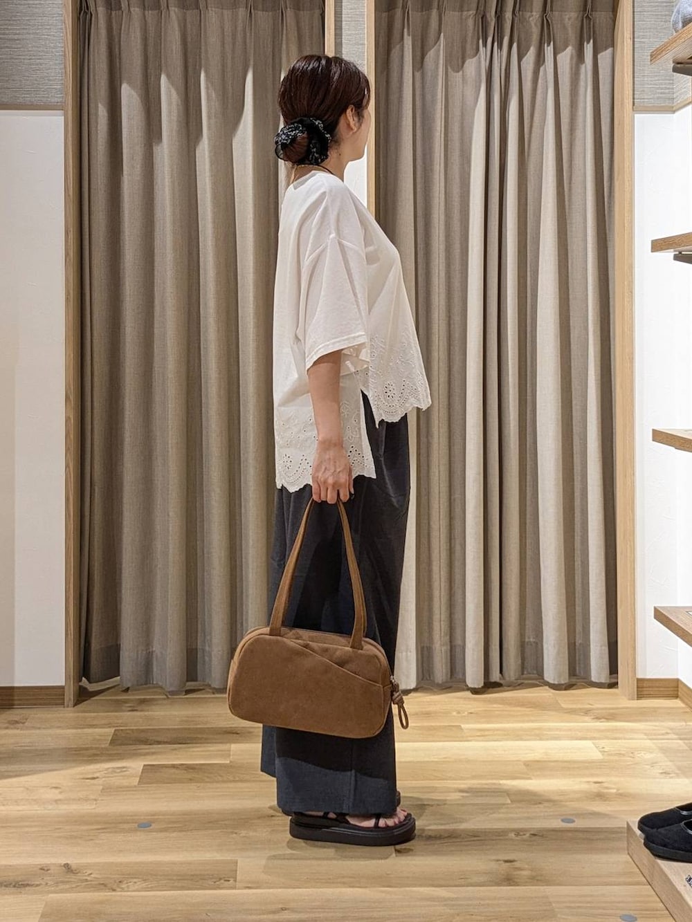 ブラウン系のショルダーバッグ、ホワイト系のTシャツ/カットソー、ブラウン系のサンダルを着用したレディースの夏コーディネートの2枚目の写真