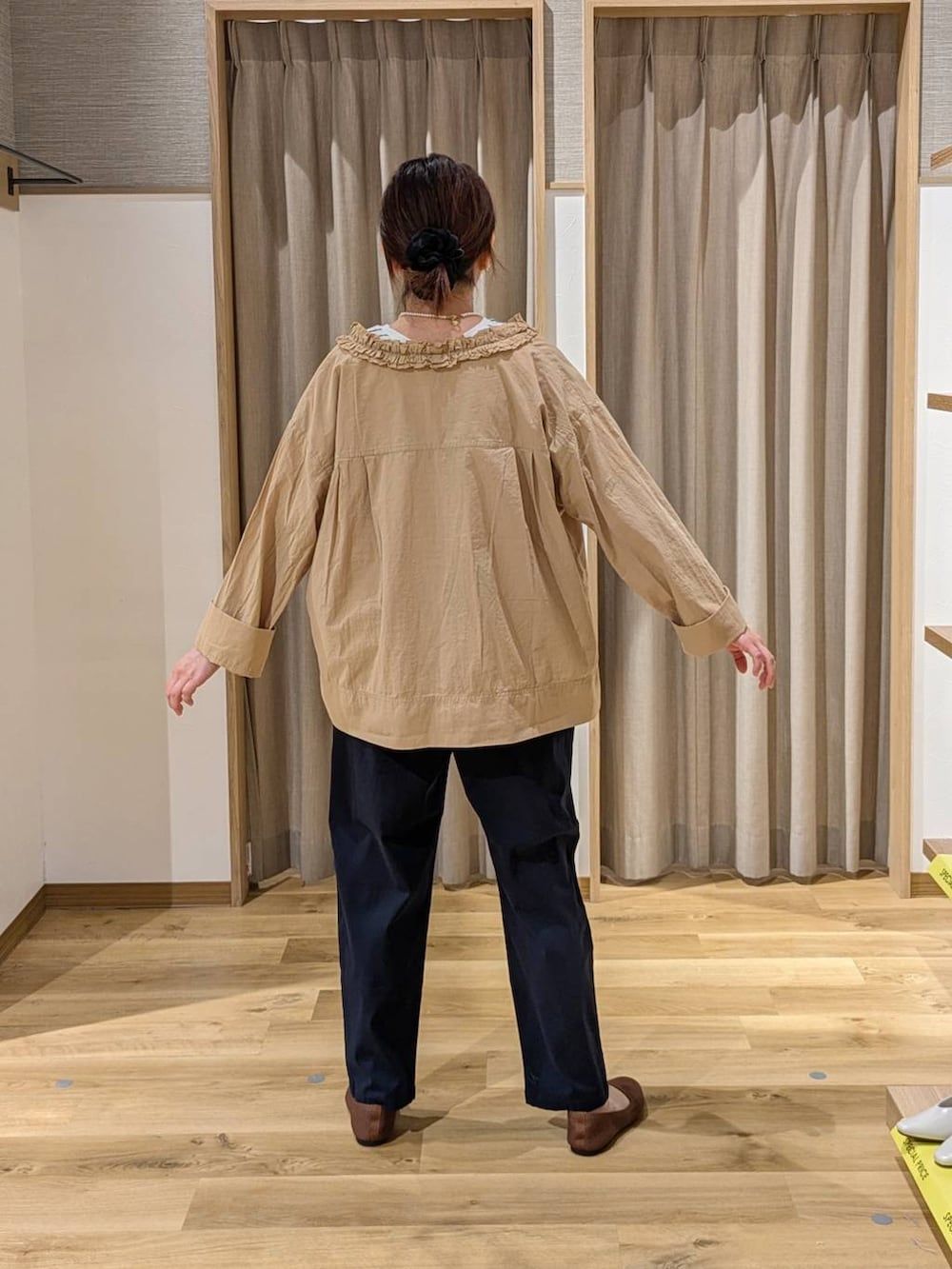 ベージュ系のシャツ/ブラウス、ブラック系のトートバッグ、ブラウン系のパンプスを着用したレディースの春コーディネートの2枚目の写真