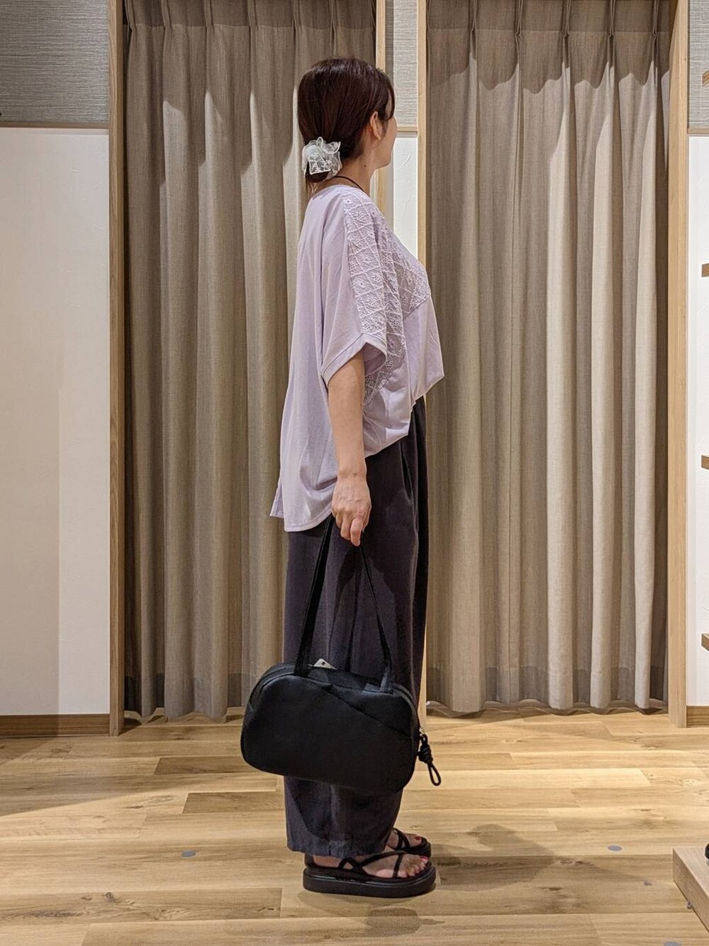 ブラック系のショルダーバッグ、パープル系のTシャツ/カットソー、ブラウン系のサンダルを着用したレディースの夏コーディネートの3枚目の写真