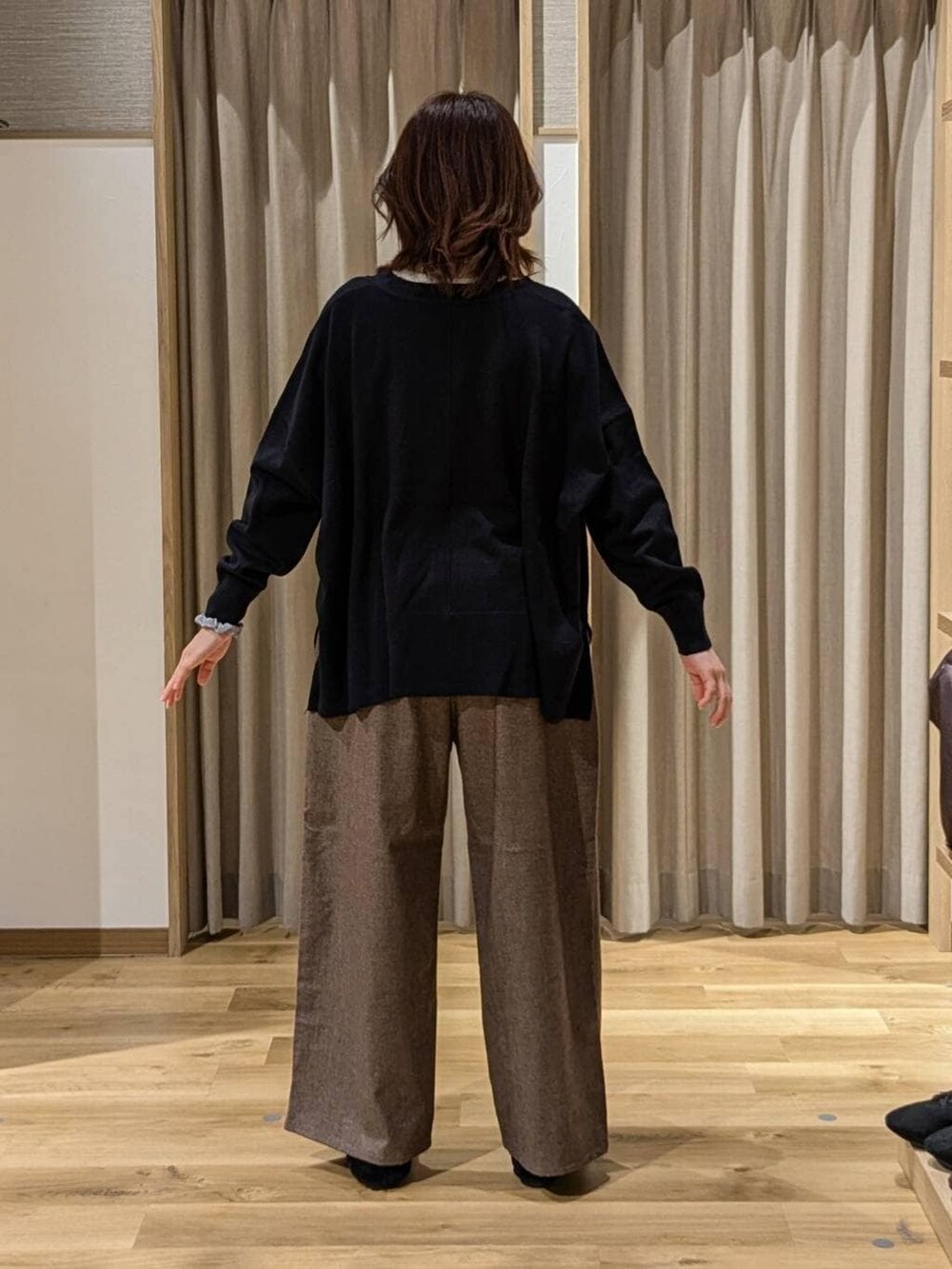 ホワイト系のTシャツ/カットソー、ブラウン系のその他パンツ、ブルー系のカーディガン/ボレロを着用したレディースの冬コーディネートの3枚目の写真