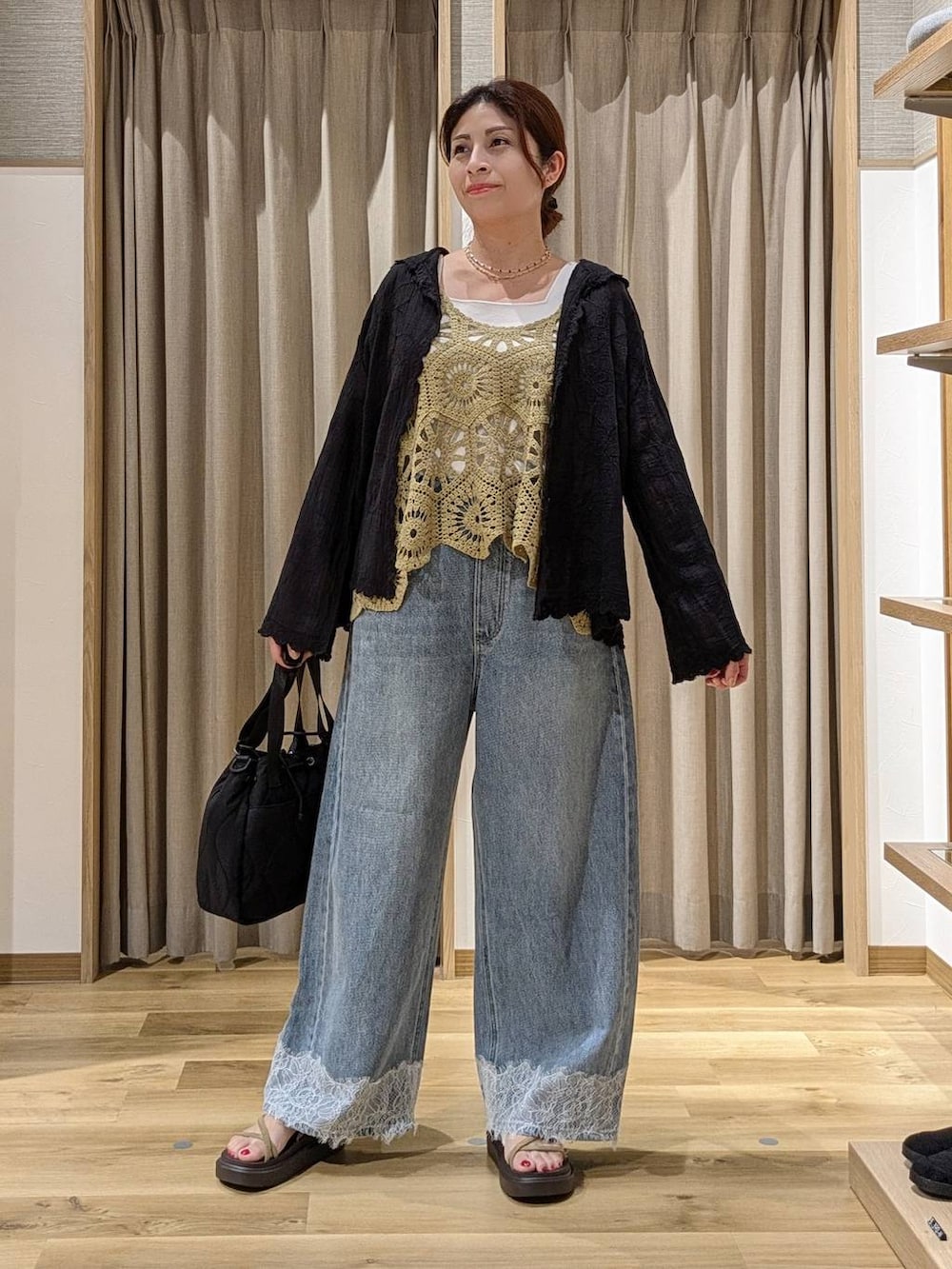 ブルー系のデニムパンツ、ブラック系のシャツ/ブラウス、ベージュ系のサンダルを着用したレディースの夏コーディネートの4枚目の写真
