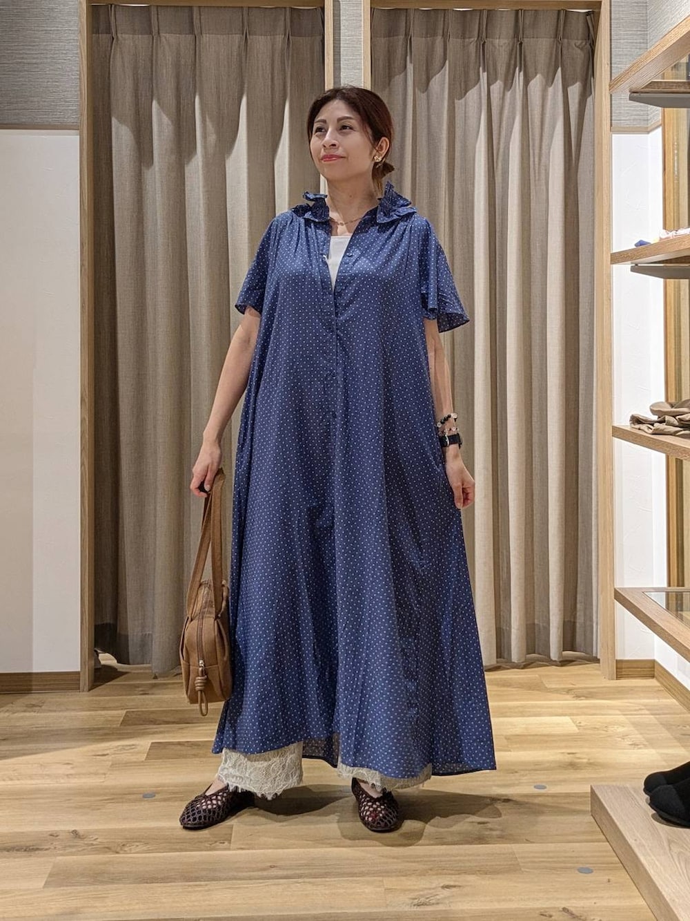 ブラウン系のショルダーバッグ、ベージュ系のデニムパンツ、ブラウン系のパンプスを着用したレディースの秋コーディネートの2枚目の写真