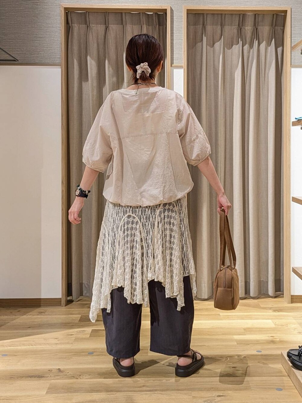 ブラウン系のショルダーバッグ、グレー系のシャツ/ブラウス、ブラウン系のサンダルを着用したレディースの夏コーディネートの2枚目の写真