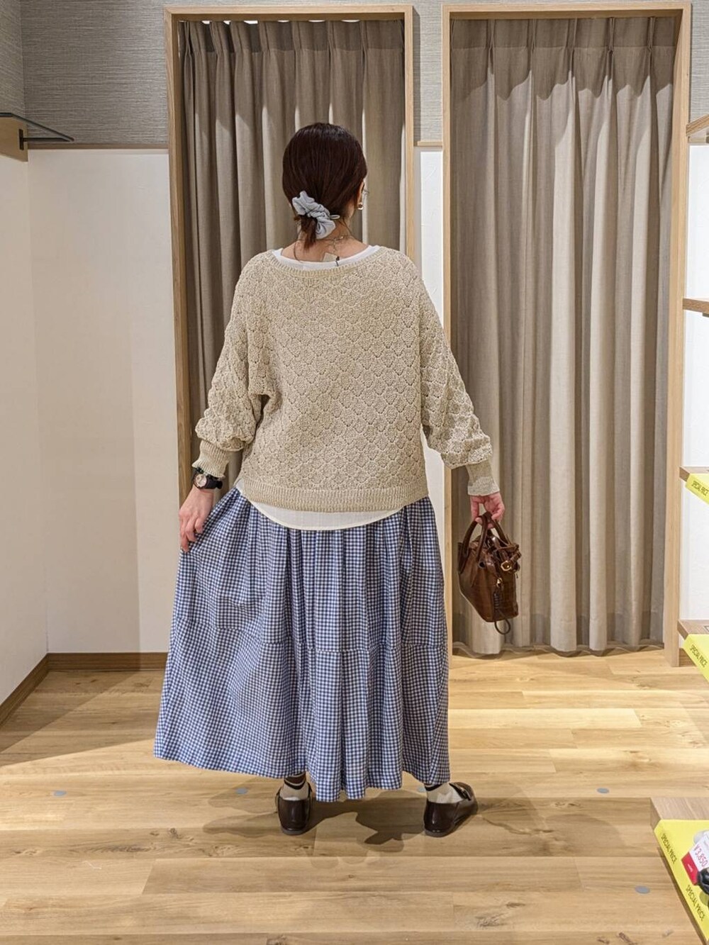 ブラウン系のトートバッグ、ブラウン系のローファー、ベージュ系のその他トップスを着用したレディースの春コーディネートの2枚目の写真