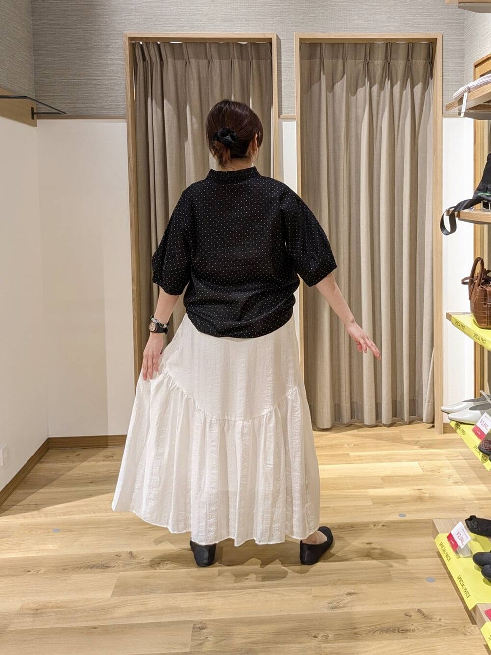 グレー系のパンプス、ホワイト系のタンクトップ、グリーン系のトートバッグを着用したレディースの春コーディネートの2枚目の写真