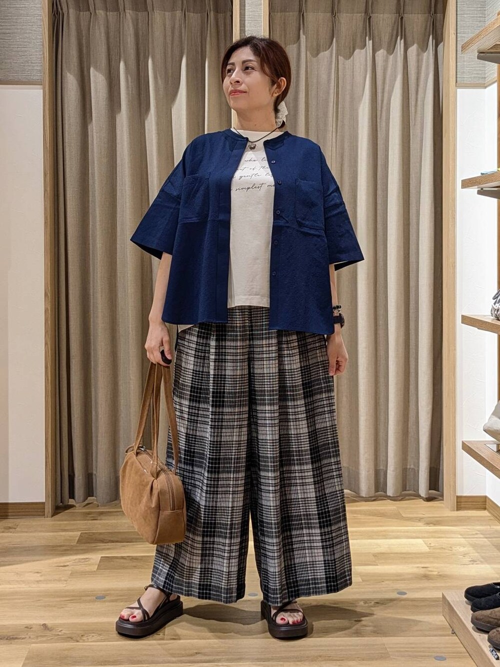 ブラウン系のショルダーバッグ、ブラウン系のサンダル、ホワイト系のその他パンツを着用したレディースの夏コーディネートの4枚目の写真