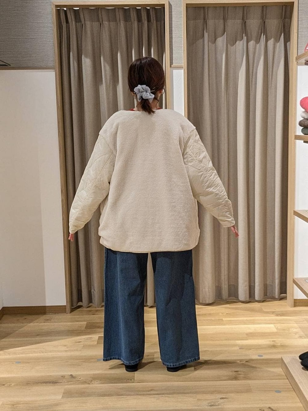 ブルー系のデニムパンツ、ホワイト系のブルゾン、レッド系のニット/セーターを着用したレディースの冬コーディネートの2枚目の写真