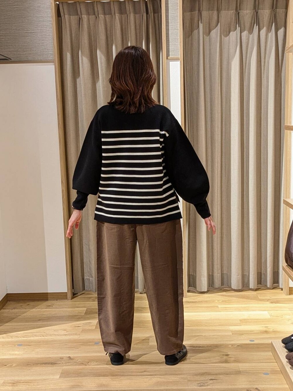 ブラウン系のその他パンツ、ブラック系のショルダーバッグ、ブラック系のスニーカーを着用したレディースの冬コーディネートの3枚目の写真