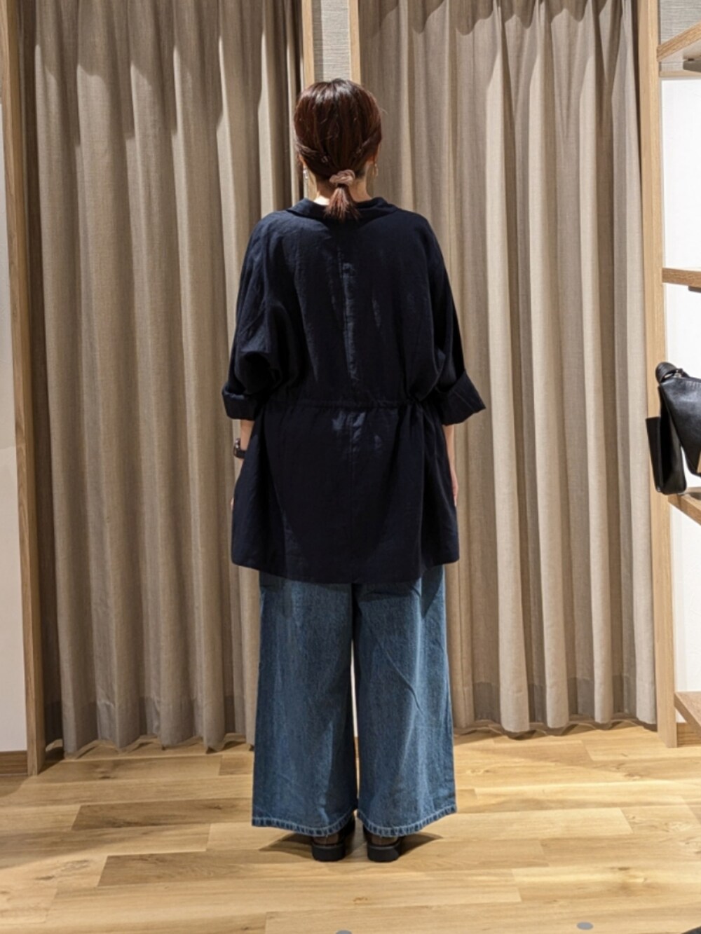 ブルー系のデニムパンツ、ブラウン系のローファー、ブルー系のその他アウターを着用したレディースの秋コーディネートの3枚目の写真