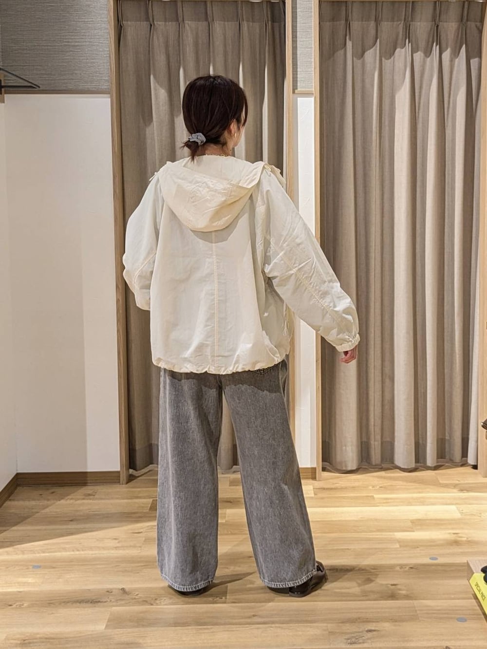 グレー系のデニムパンツ、ベージュ系のマウンテンパーカー、ブルー系のスウェットを着用したレディースの春コーディネートの2枚目の写真