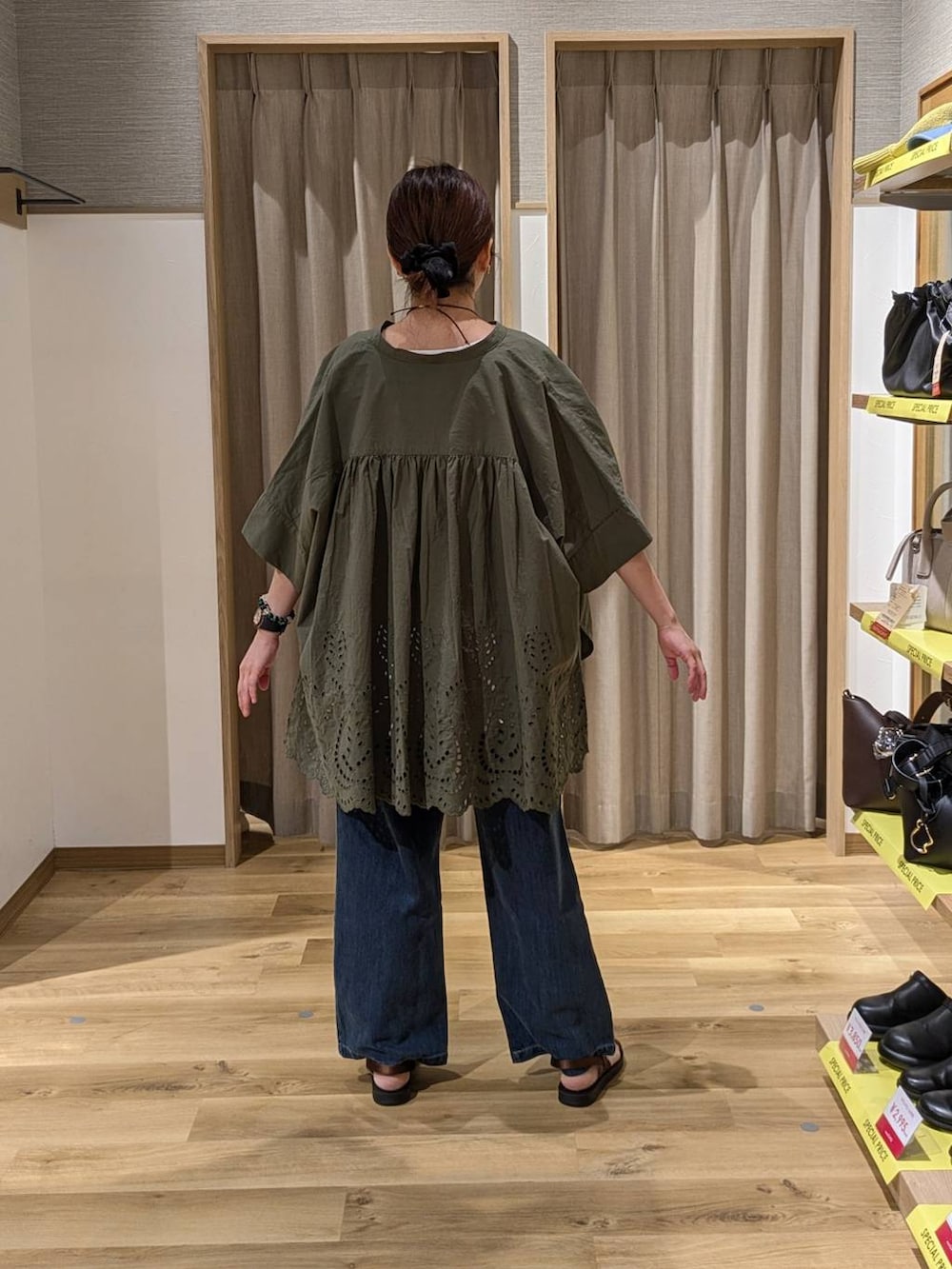 ブラウン系のショルダーバッグ、ブラウン系のサンダル、ブルー系のデニムパンツを着用したレディースの夏コーディネートの2枚目の写真