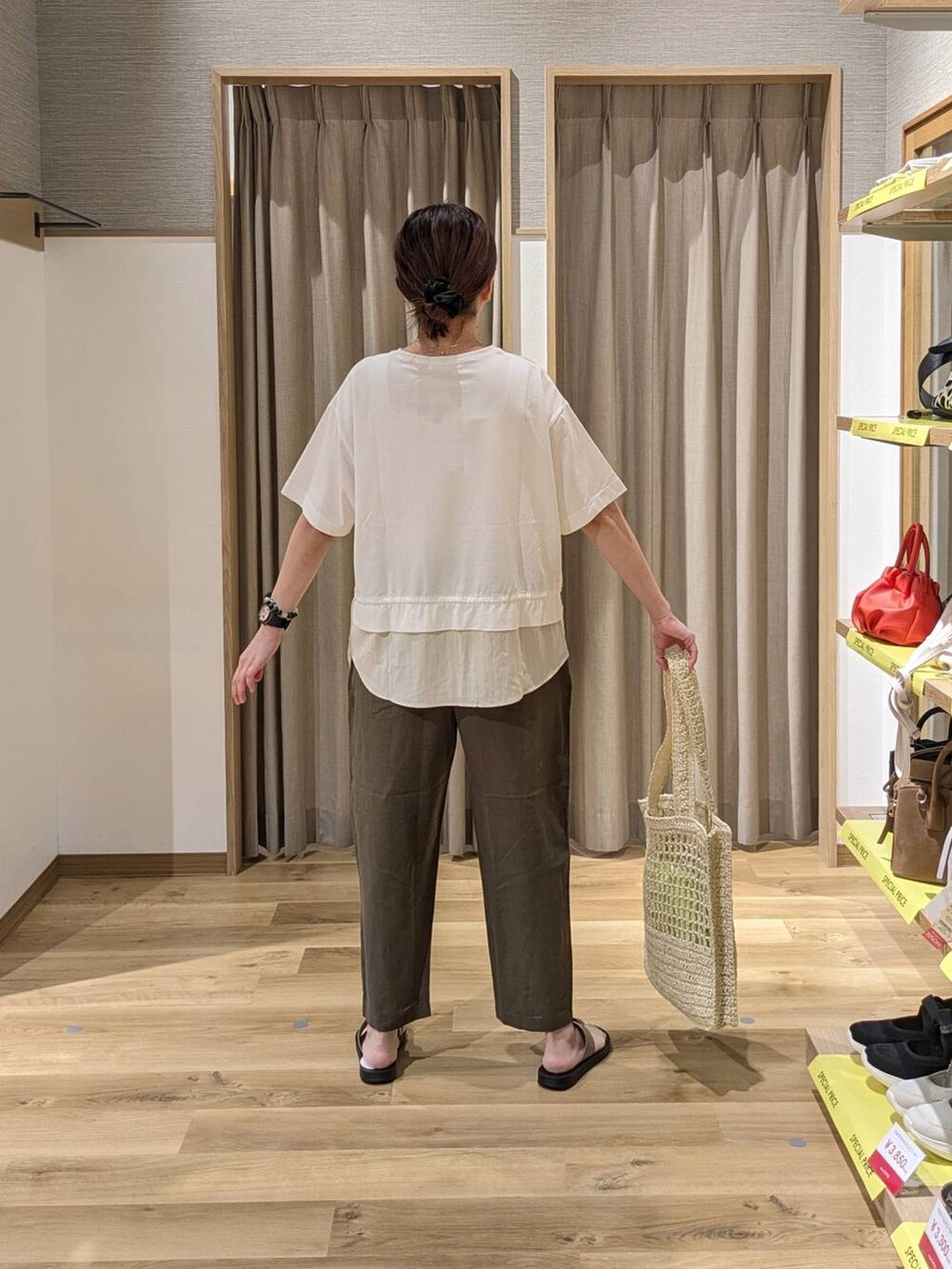 ベージュ系のトートバッグ、ベージュ系のサンダル、ホワイト系のTシャツ/カットソーを着用したレディースの夏コーディネートの2枚目の写真