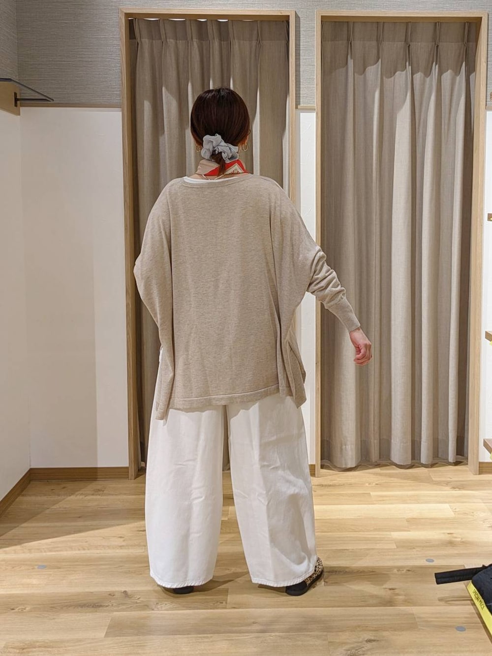 ホワイト系のデニムパンツ、その他のスニーカー、ブラウン系のトートバッグを着用したレディースの春コーディネートの2枚目の写真