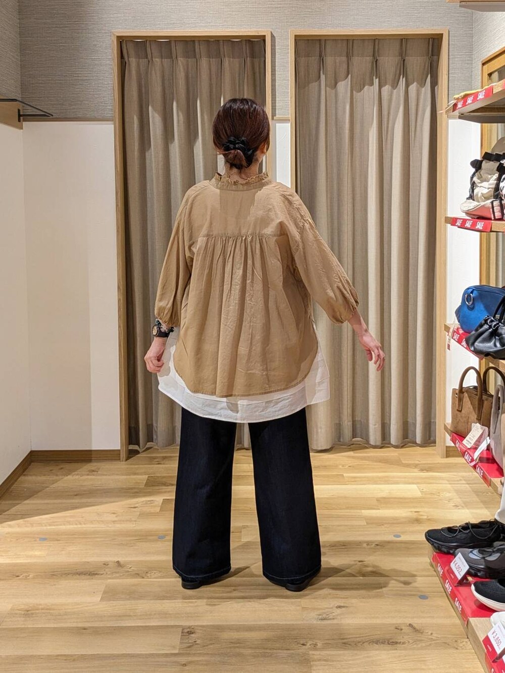 ブラック系のショルダーバッグ、ゴールド系のサンダル、ブルー系のデニムパンツを着用したレディースの夏コーディネートの2枚目の写真