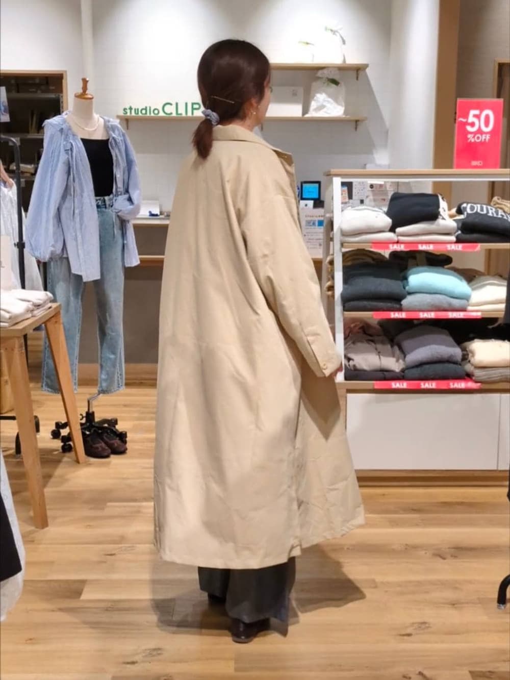 グレー系のベスト、グレー系のスラックス、ベージュ系のチェスターコートを着用したレディースの冬コーディネートの3枚目の写真