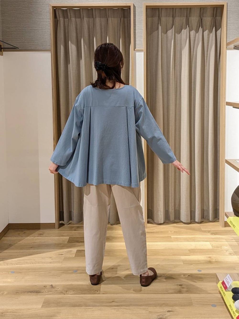 ブラウン系のショルダーバッグ、ブラウン系のパンプス、ブルー系のTシャツ/カットソーを着用したレディースの春コーディネートの2枚目の写真