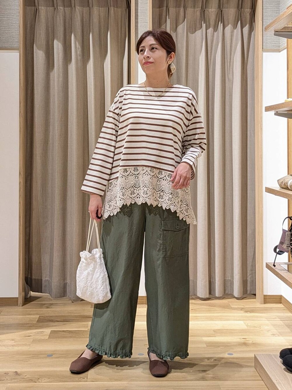 グリーン系のその他パンツ、ホワイト系のTシャツ/カットソー、その他のネックレスを着用したレディースの秋コーディネートの2枚目の写真