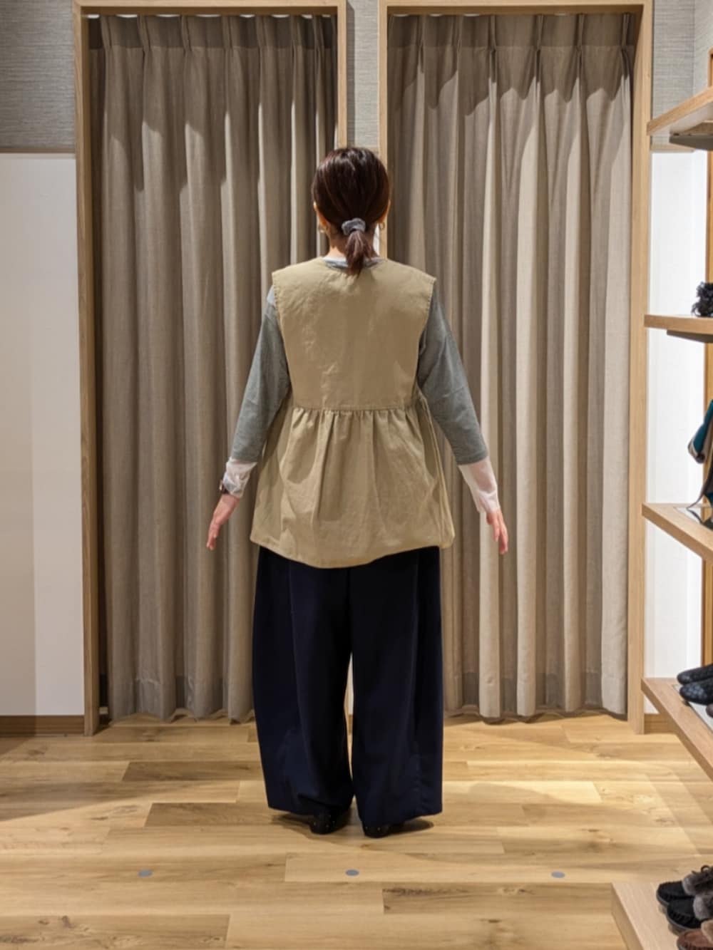 ブルー系のその他パンツ、ベージュ系のベスト、ブラック系のショルダーバッグを着用したレディースの秋コーディネートの2枚目の写真