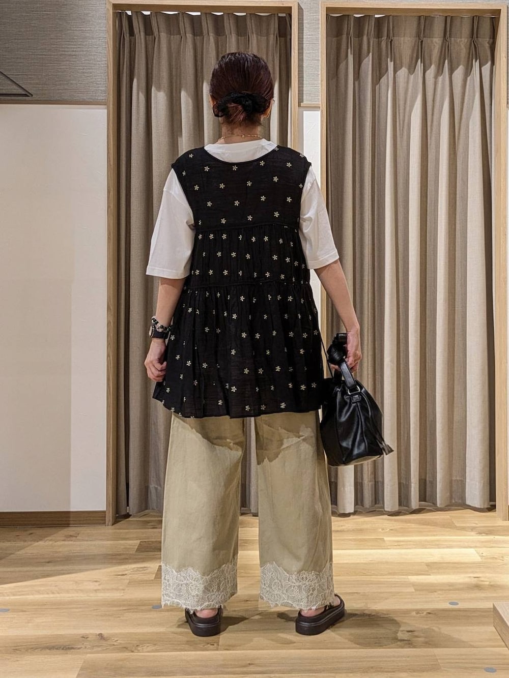 ベージュ系のデニムパンツ、ホワイト系のTシャツ/カットソー、ブラック系のチュニックを着用したレディースの夏コーディネートの3枚目の写真