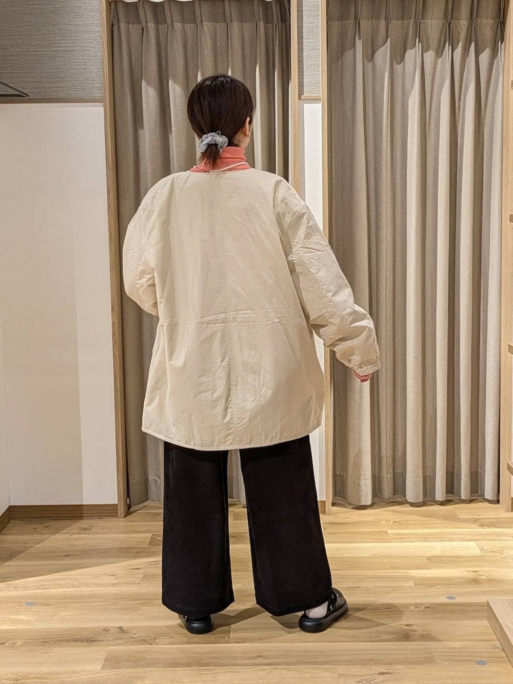 ベージュ系のノーカラーコート、ブラック系のサンダル、ブラック系のショルダーバッグを着用したレディースの冬コーディネートの2枚目の写真