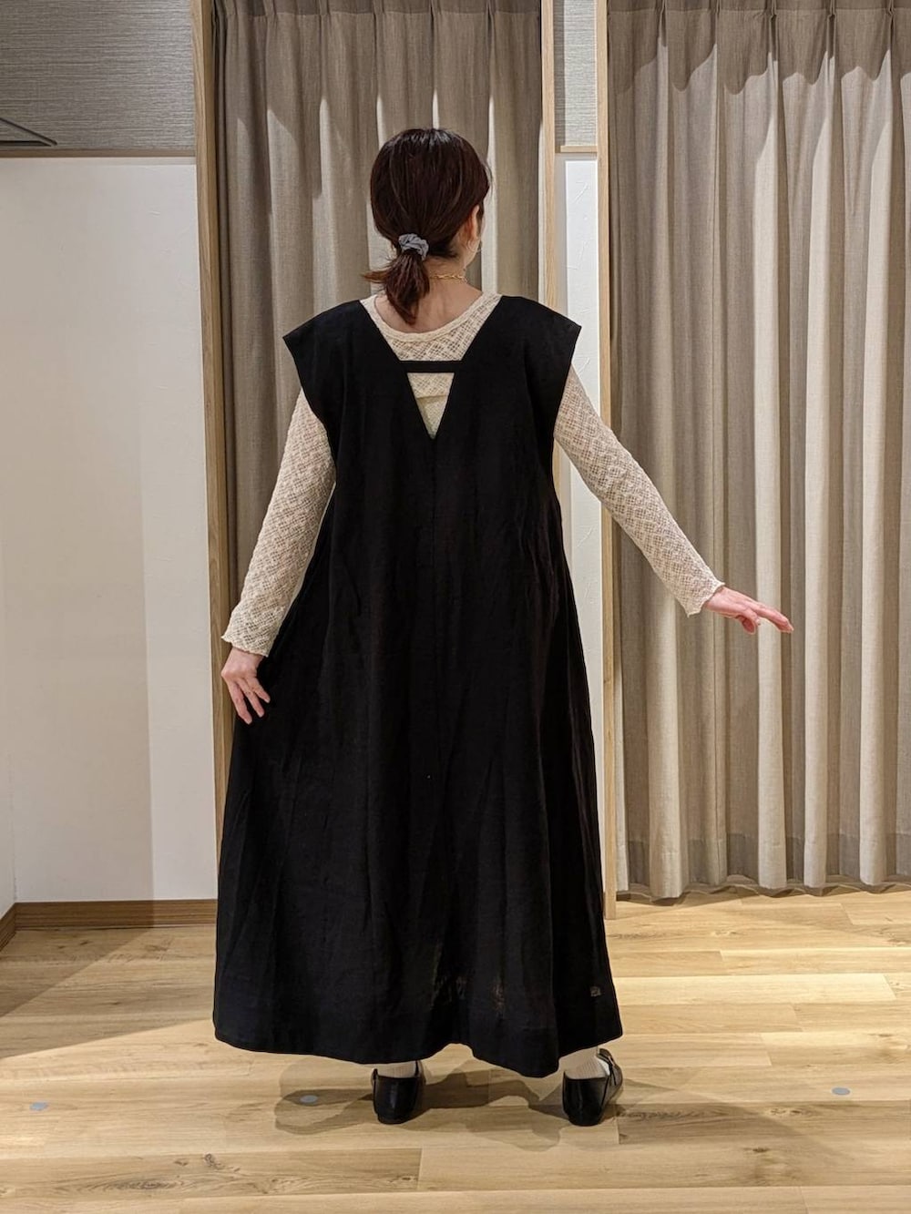 グレー系のその他パンツ、ブラウン系のトートバッグ、ブラック系のジャンパースカートを着用したレディースの春コーディネートの2枚目の写真