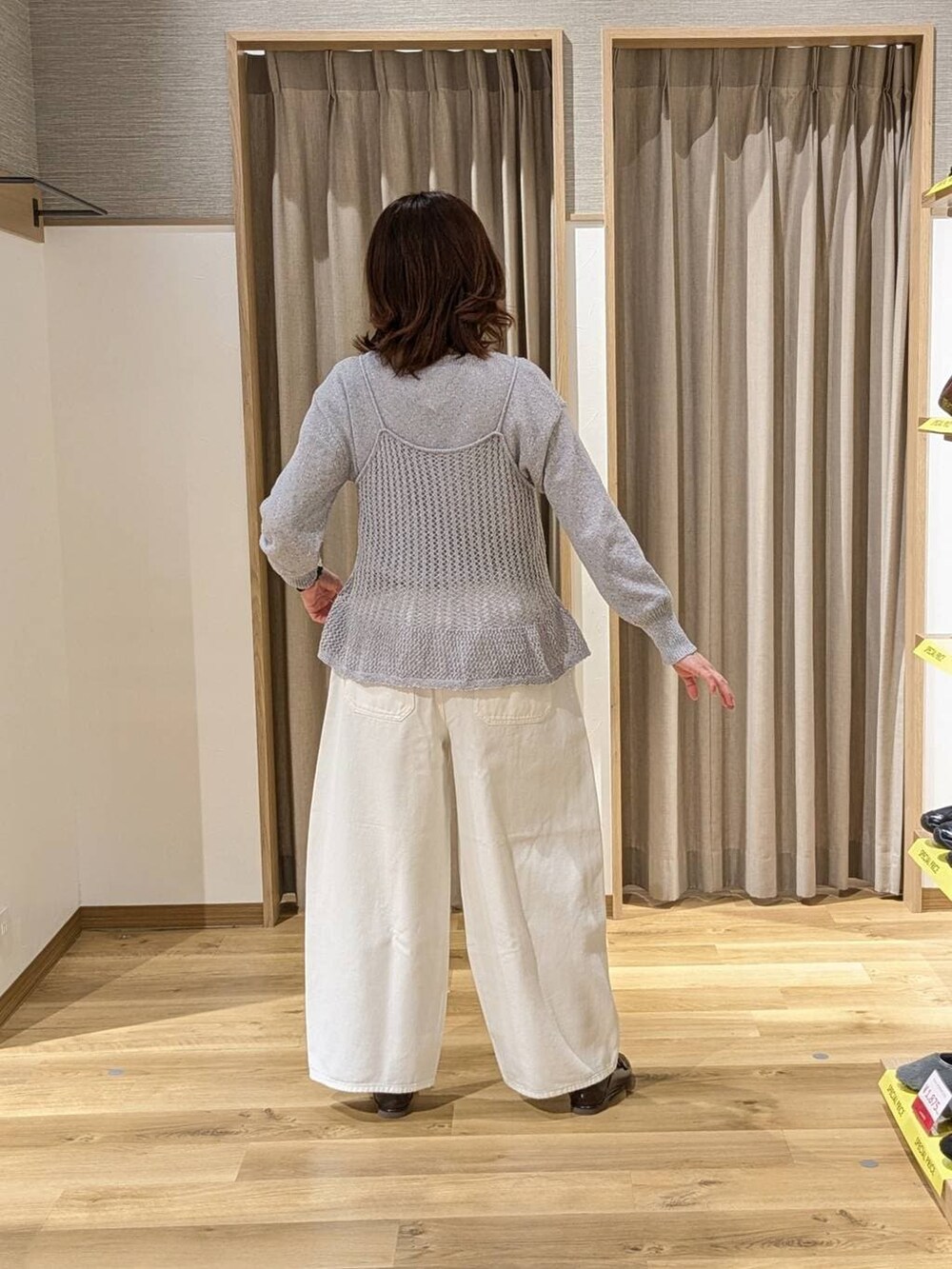 ホワイト系のデニムパンツ、ブラウン系のトートバッグ、ブラウン系のローファーを着用したレディースの冬コーディネートの2枚目の写真