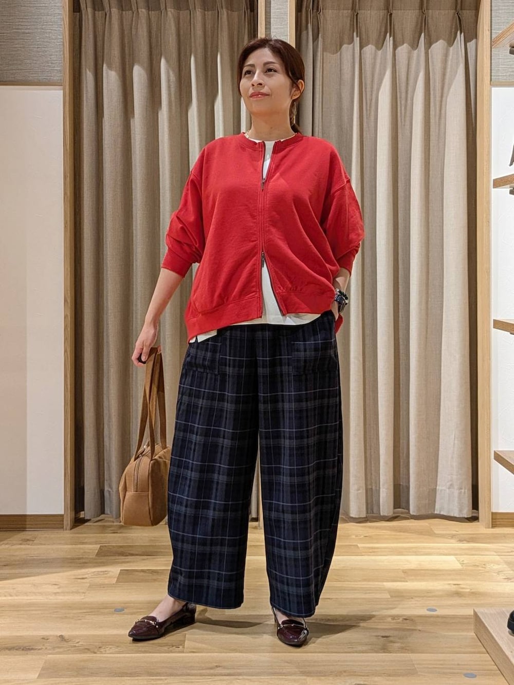 ブラウン系のショルダーバッグ、レッド系のスウェット、ホワイト系のTシャツ/カットソーを着用したレディースの秋コーディネートの4枚目の写真