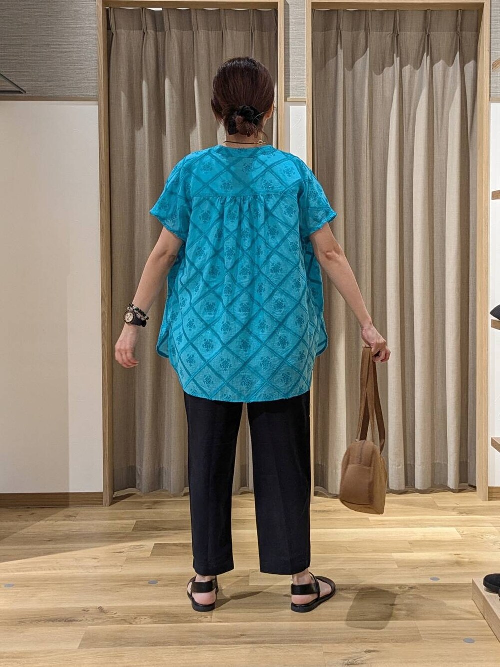 ブラウン系のショルダーバッグ、ブルー系のその他パンツ、ブラウン系のサンダルを着用したレディースの夏コーディネートの3枚目の写真