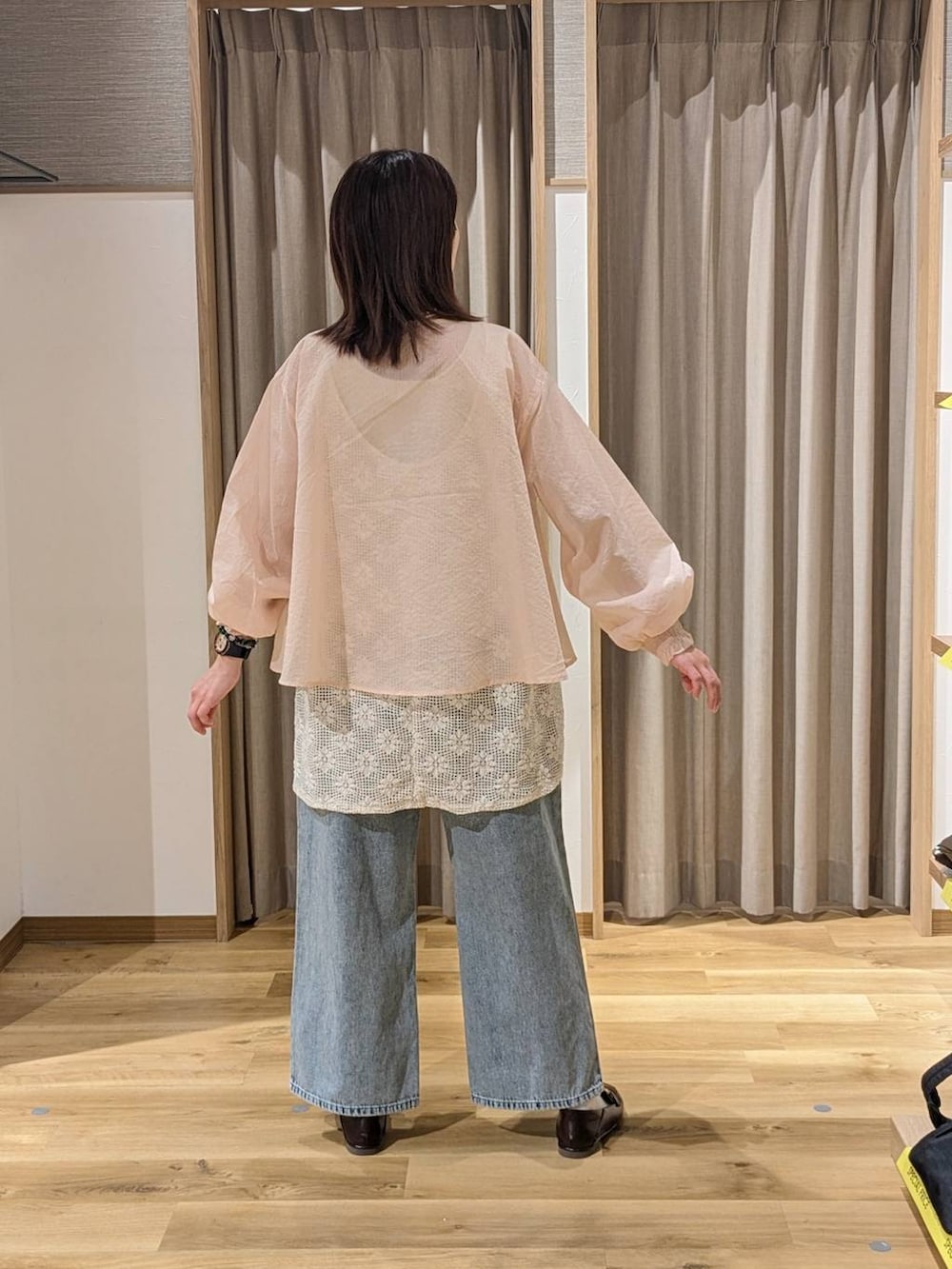 ブルー系のデニムパンツ、ブラウン系のトートバッグ、ブラウン系のローファーを着用したレディースの春コーディネートの2枚目の写真