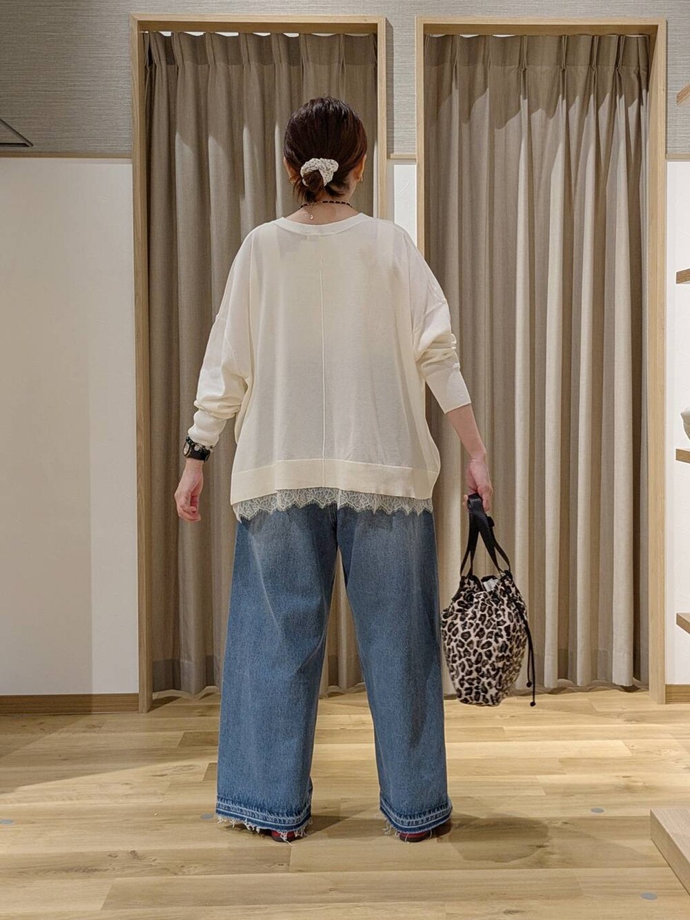 レッド系のその他シューズ、ホワイト系のカーディガン/ボレロ、ブルー系のデニムパンツを着用したレディースの秋コーディネートの3枚目の写真