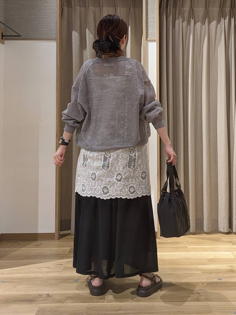 ブラック系のその他パンツ、ホワイト系のチュニック、ブラウン系のサンダルを着用したレディースの夏コーディネートの3枚目の写真