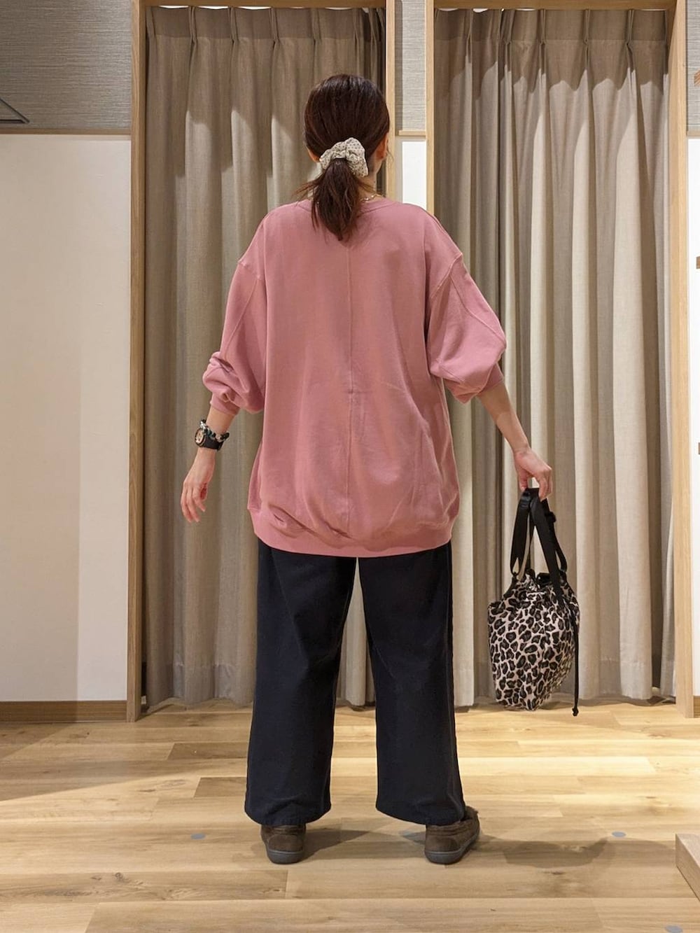 ピンク系のスウェット、ブラウン系のモカシン/デッキシューズ、ブラウン系のショルダーバッグを着用したレディースの秋コーディネートの3枚目の写真