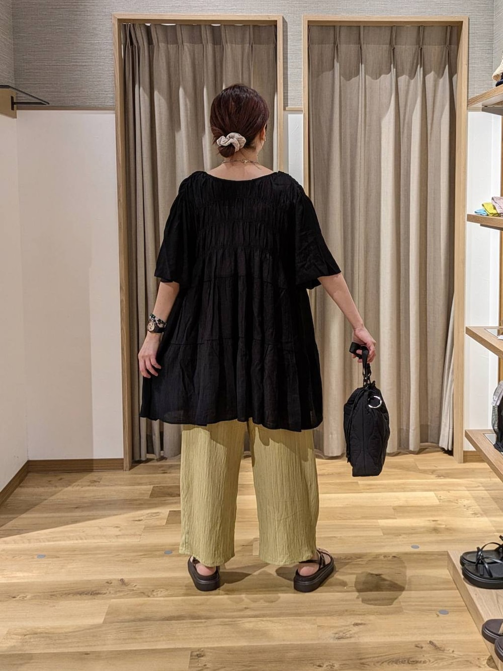 イエロー系のその他パンツ、ブラック系のショルダーバッグ、ブラウン系のサンダルを着用したレディースの夏コーディネートの2枚目の写真