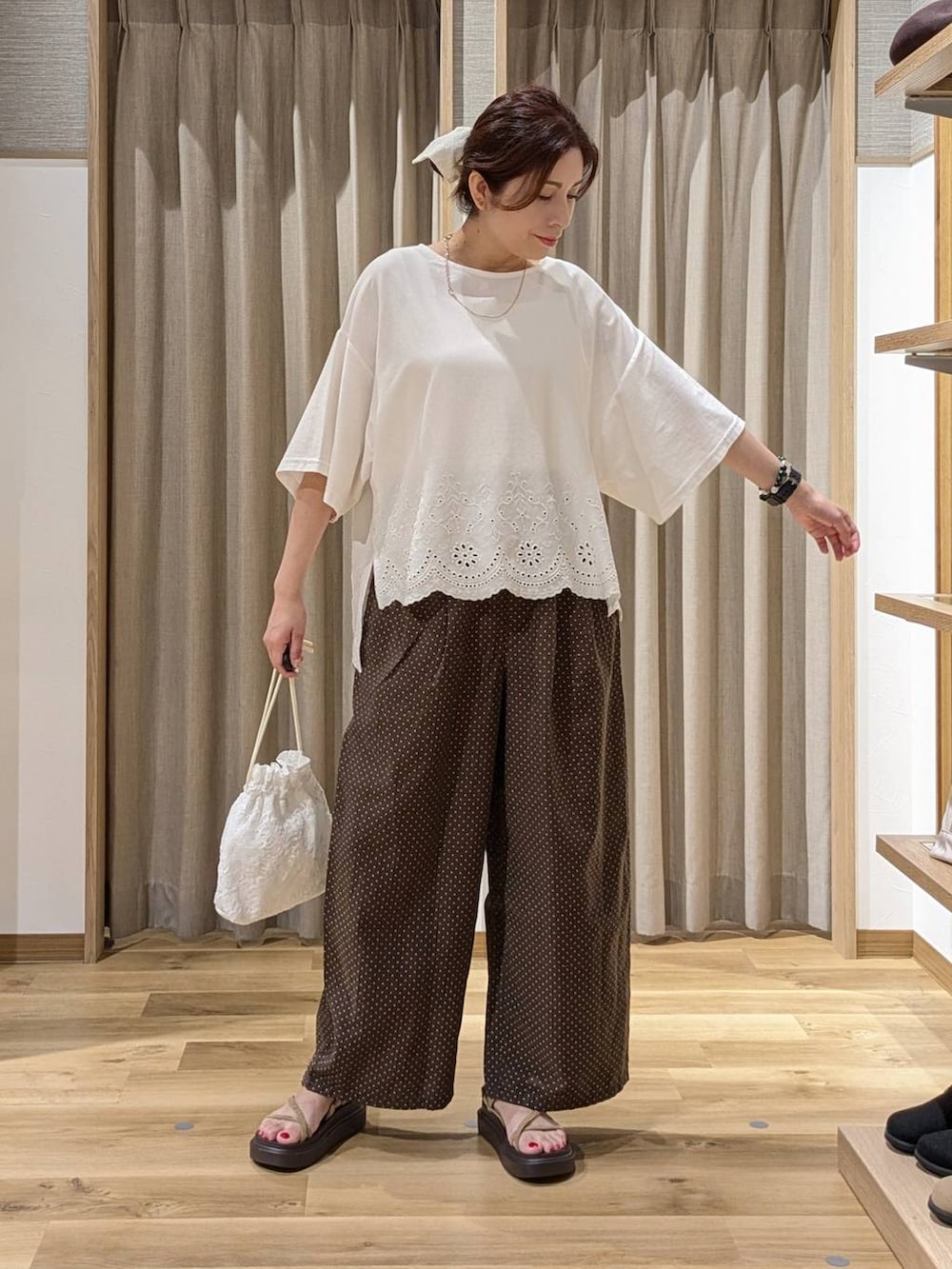 ホワイト系のTシャツ/カットソー、ベージュ系のサンダル、ブラウン系のその他パンツを着用したレディースの夏コーディネートの2枚目の写真