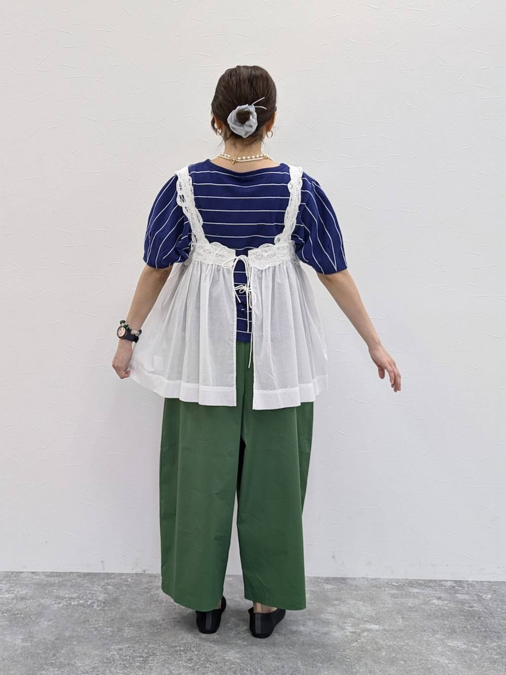 ホワイト系のベスト、グレー系のパンプス、グレー系のシュシュを着用したレディースの春コーディネートの2枚目の写真