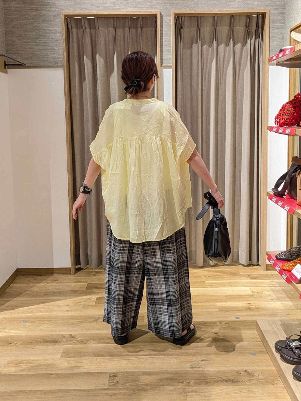 ブラック系のサンダル、ホワイト系のタンクトップ、ホワイト系のその他パンツを着用したレディースの夏コーディネートの2枚目の写真