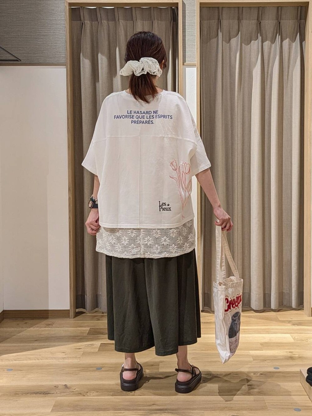 ブラウン系のサンダル、ホワイト系のベスト、ホワイト系のTシャツ/カットソーを着用したレディースの夏コーディネートの3枚目の写真