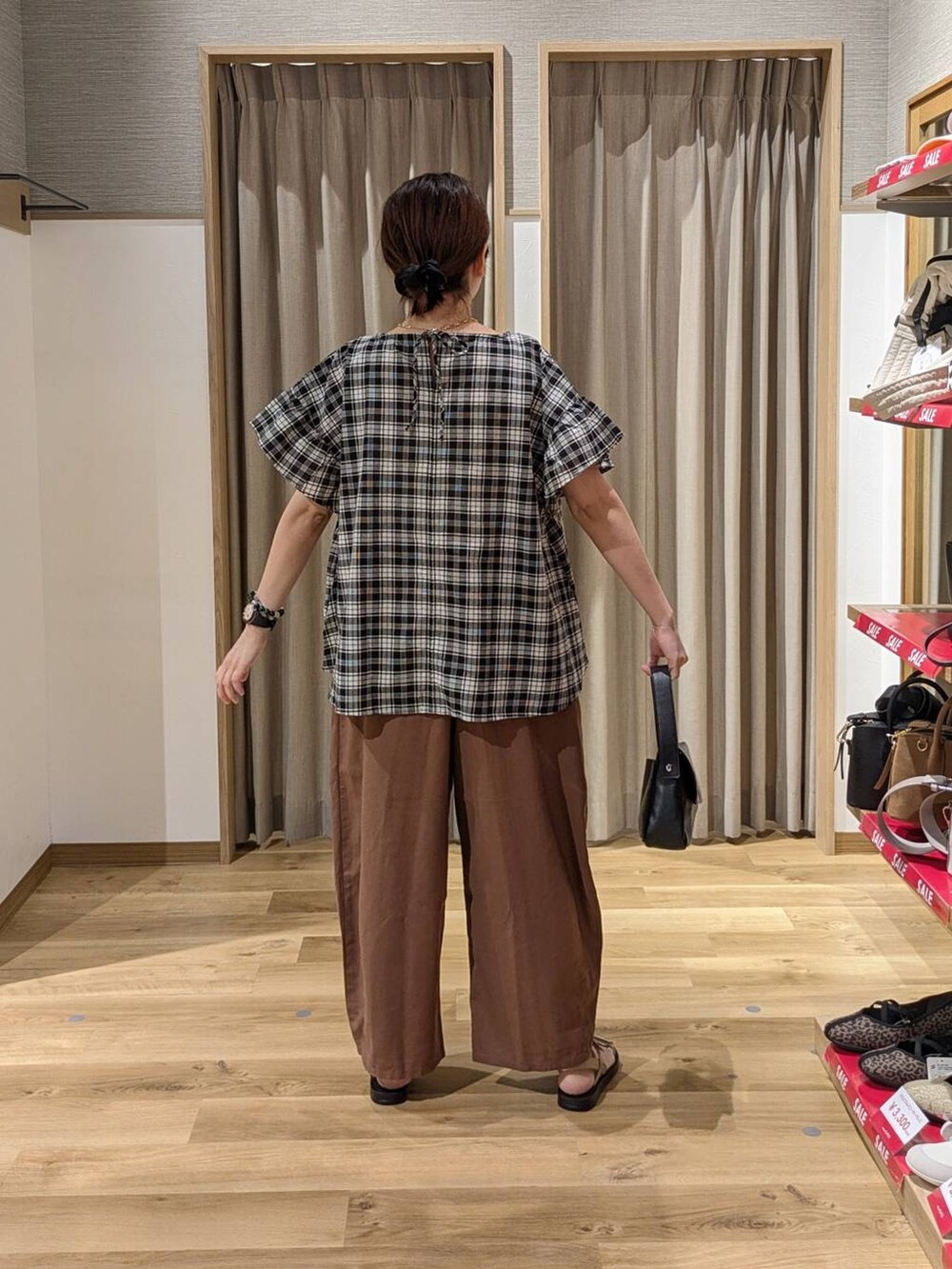 ゴールド系のサンダル、ブラウン系のその他パンツ、ブラック系のシャツ/ブラウスを着用したレディースの夏コーディネートの2枚目の写真