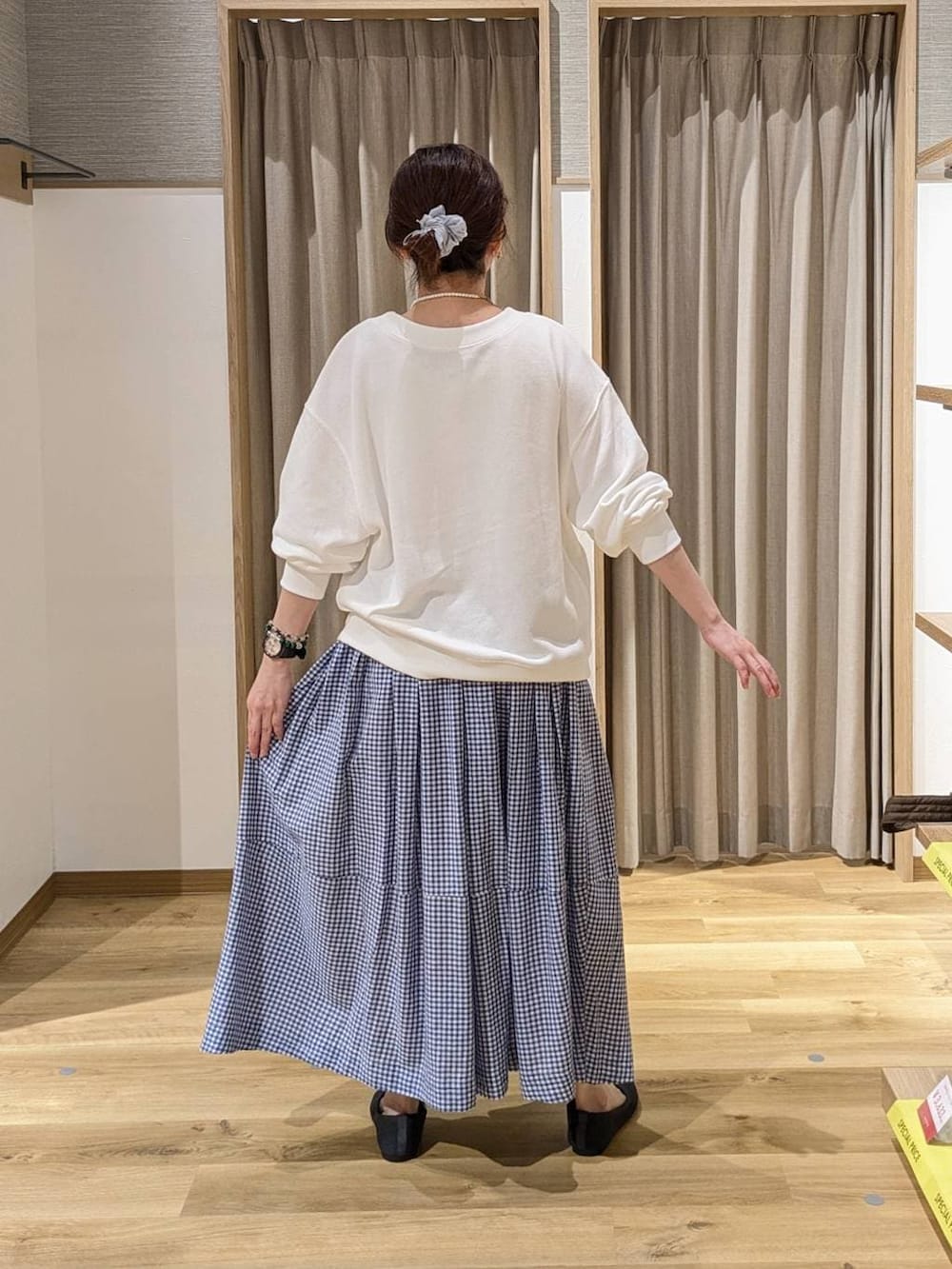 ホワイト系のスウェット、グレー系のパンプス、ベージュ系のトートバッグを着用したレディースの春コーディネートの2枚目の写真