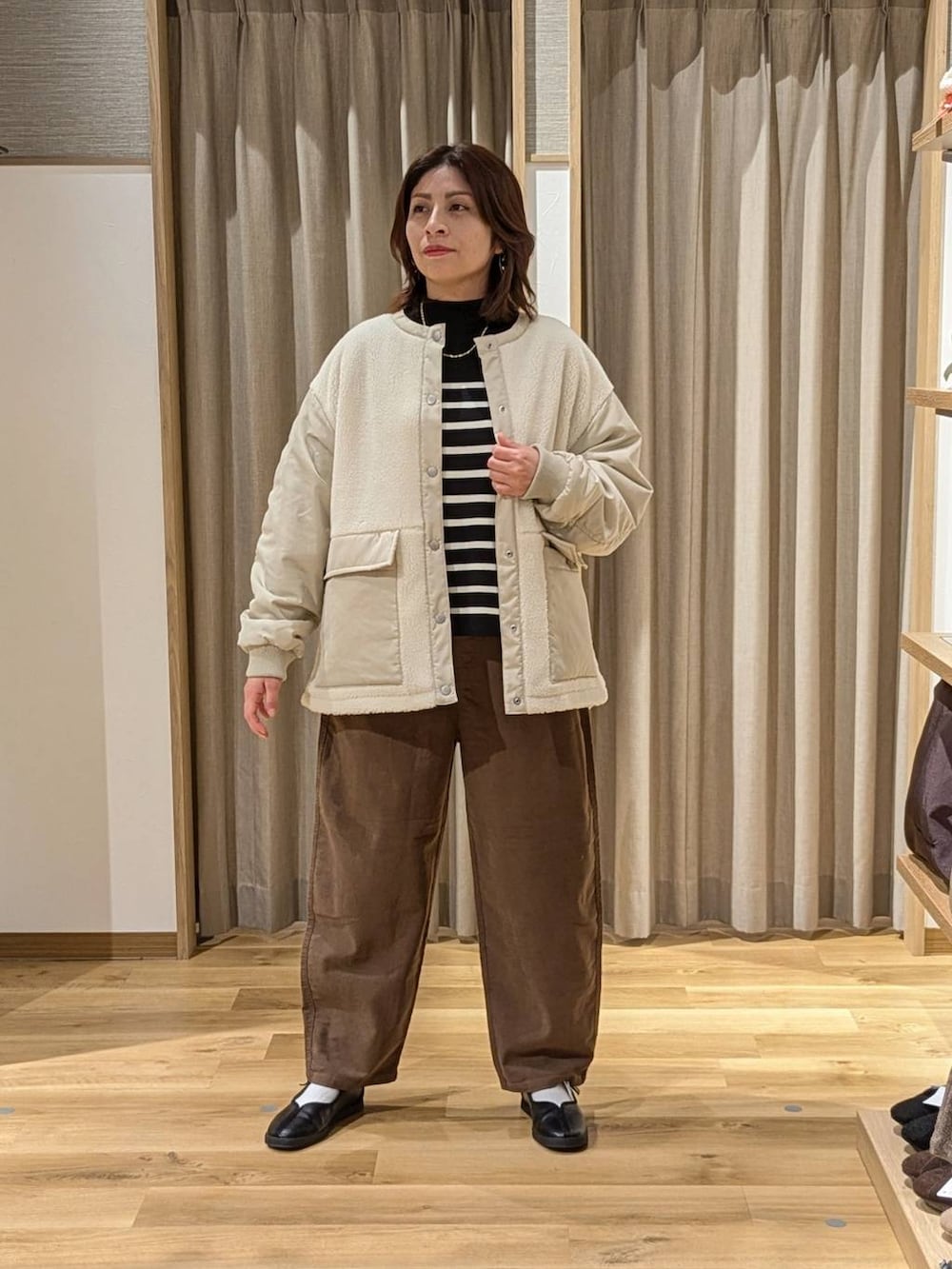 ブラウン系のその他パンツ、ホワイト系のその他アウター、ブラック系のスニーカーを着用したレディースの冬コーディネートの2枚目の写真