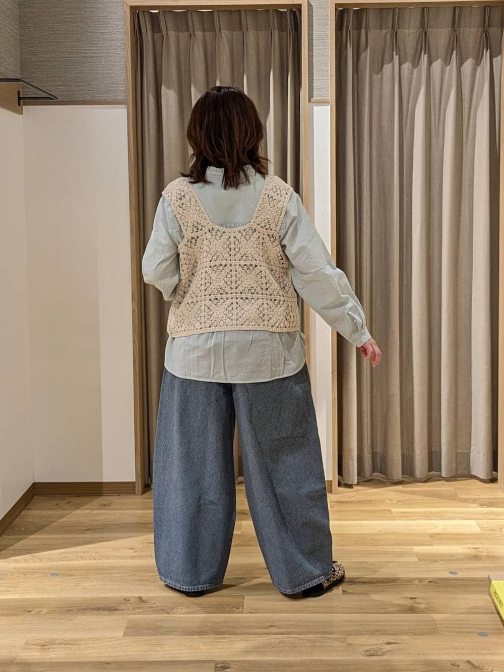 ベージュ系のベスト、ブラック系のショルダーバッグ、その他のスニーカーを着用したレディースの冬コーディネートの3枚目の写真