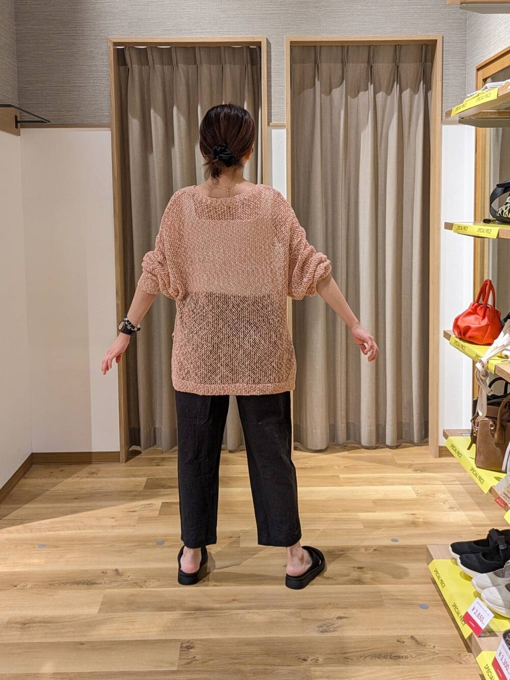 ブラック系のショルダーバッグ、オレンジ系のTシャツ/カットソー、ブラック系のサンダルを着用したレディースの夏コーディネートの2枚目の写真